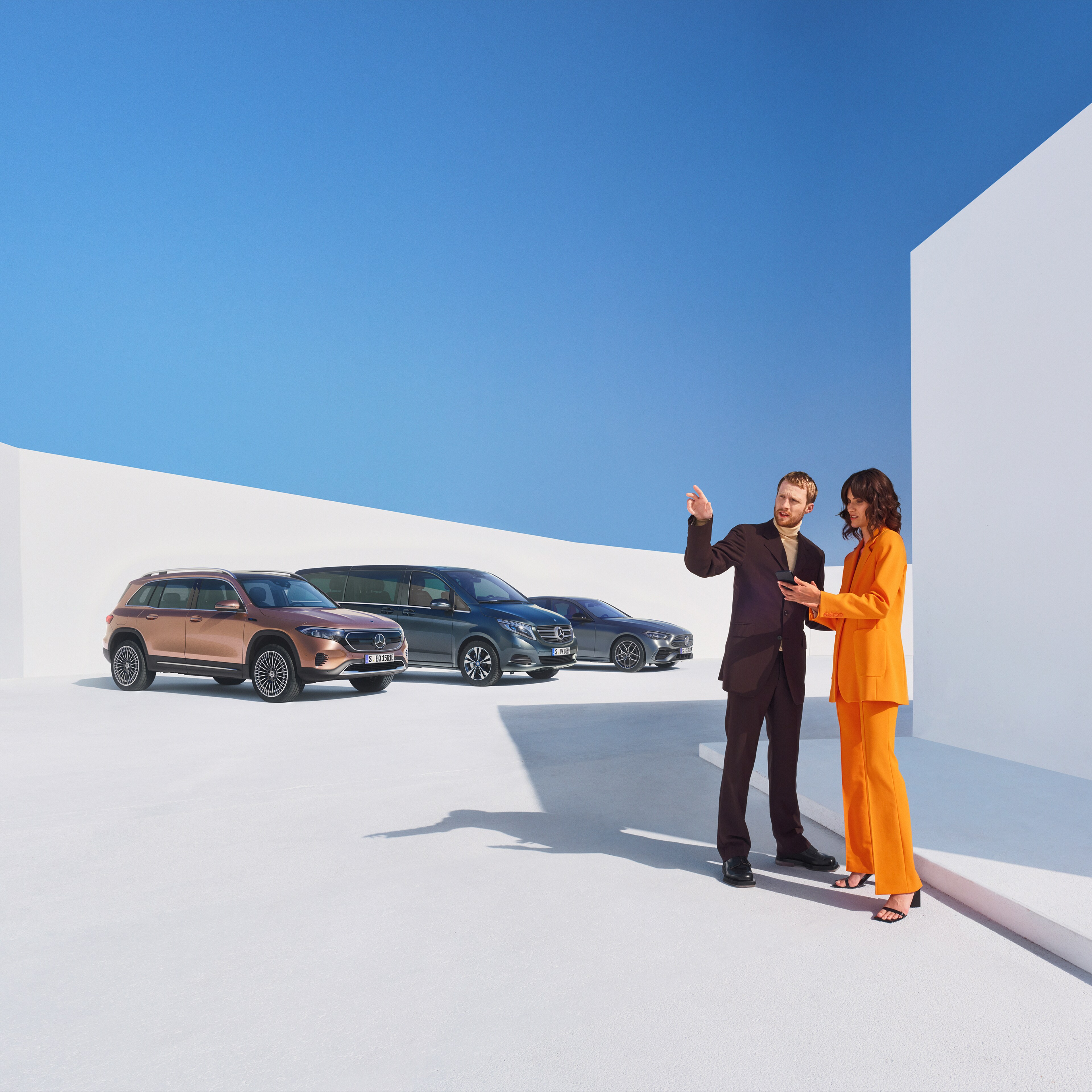 Tjänstebilar | Mercedes-Benz Två personer pratar bredvid en rad av olika Mercedes-Benz modeller