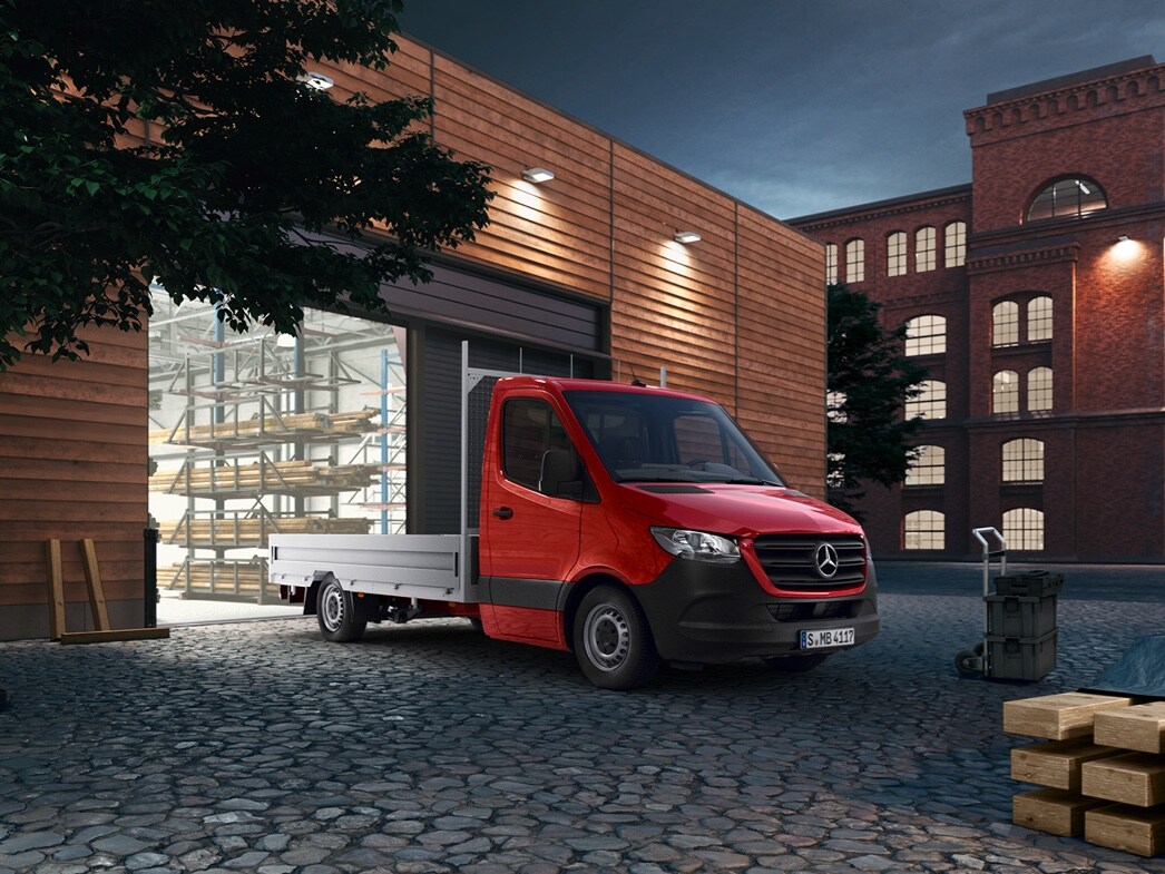 Flakbil | Arbetsbilar | Mercedes-Benz Transportbilar Röd Sprinter Flakbil från Mercedes-Benz framför lagerbyggnad
