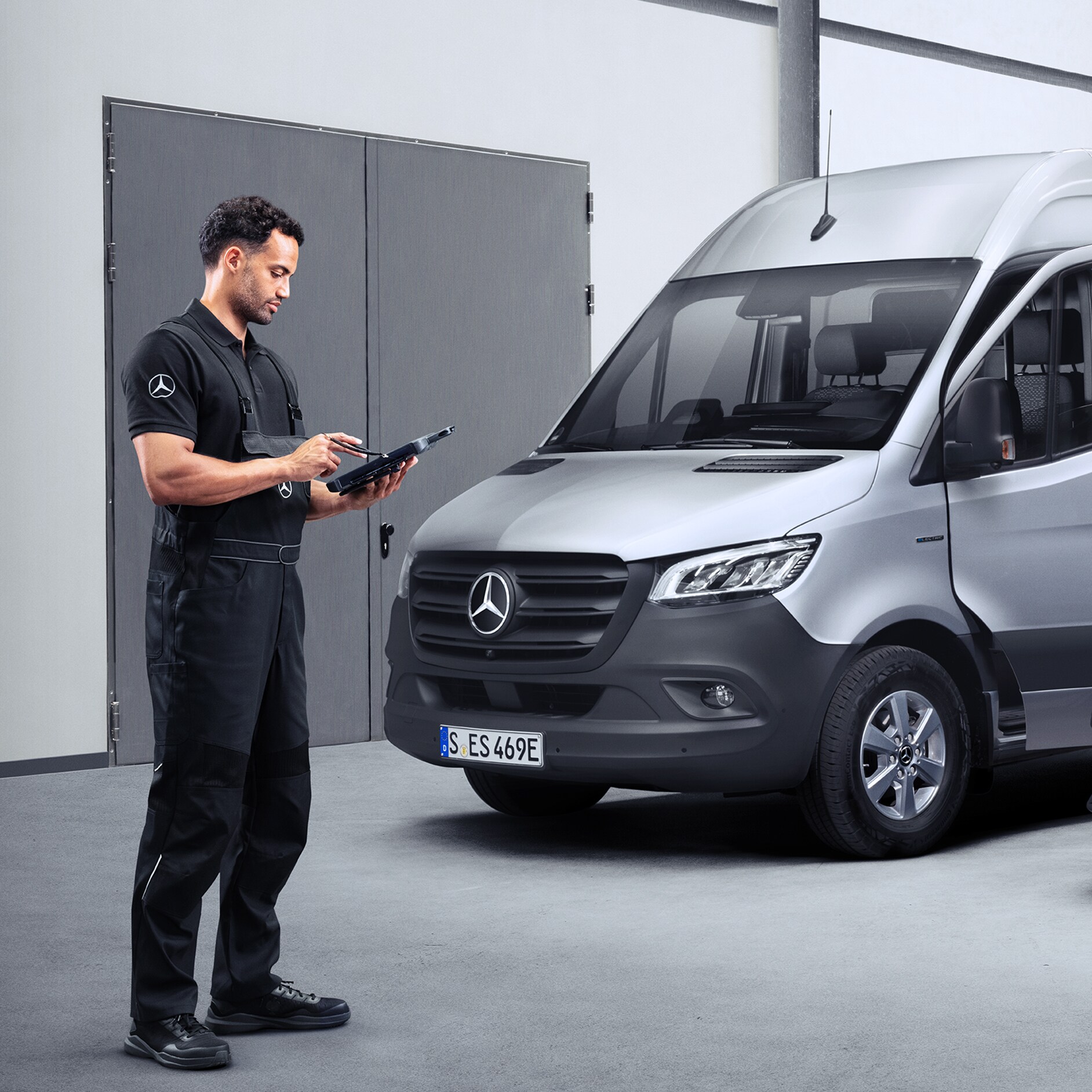 Mercedes-Benz | Transportbilar Kvalitet Garanti En tekniker som står framför en Mercedes-Benz Sprinter och arbetar med sitt diagnosverktyg