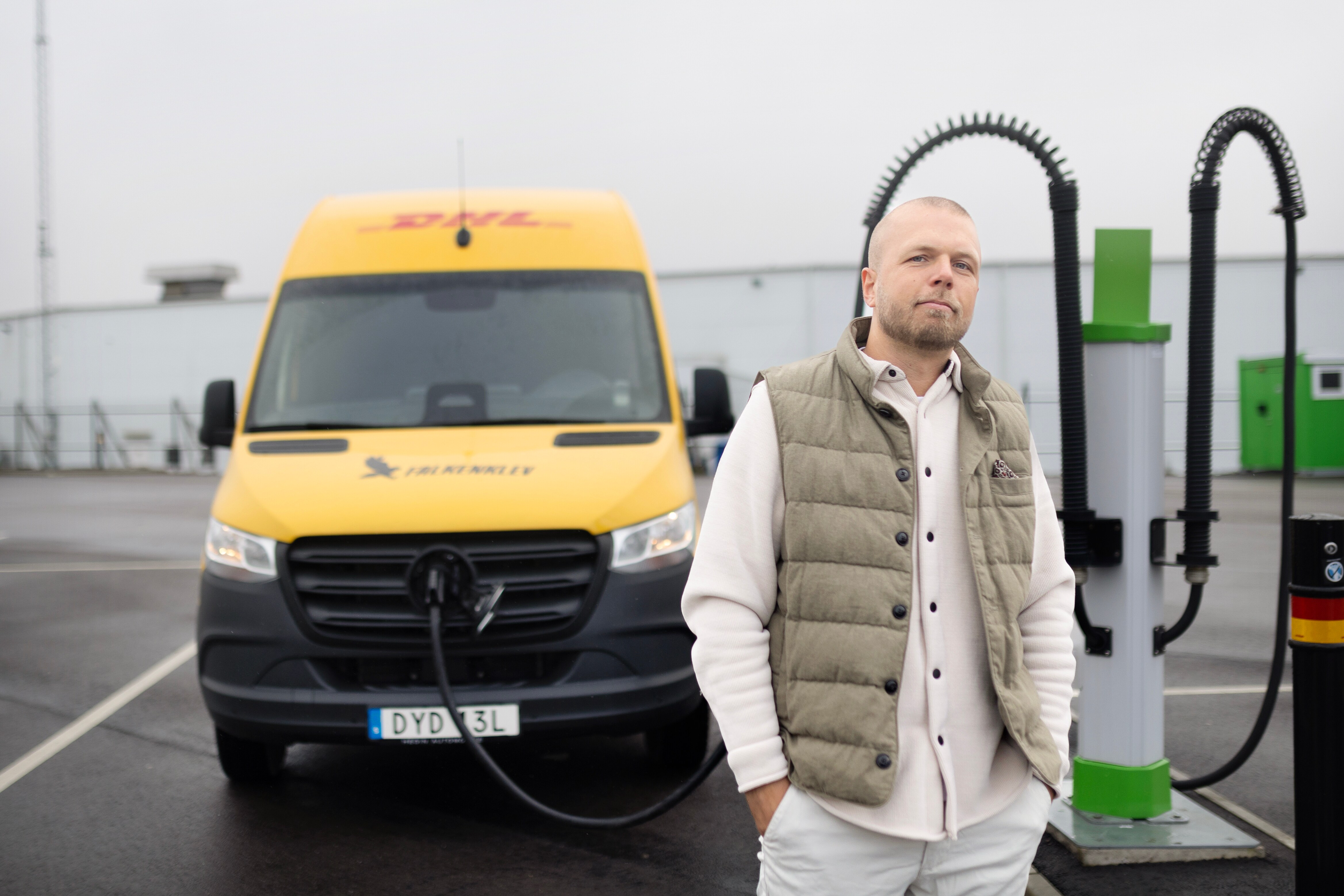 Kundberättelser | Transportbilar på el | Mercedes-Benz Transportbilar Man står framför Mercedes-Benz transportbil som laddas vid en laddstation.