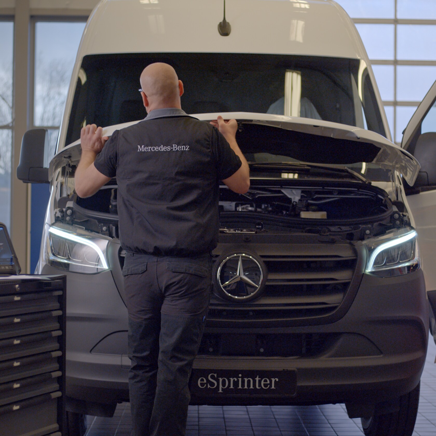Serviceavtal | Mercedes-Benz Transportbilar Servicetekniker öppnar huven på en Mercedes-Benz eSprinter